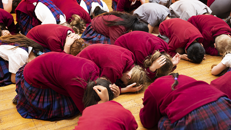 Primary school students doing Drop Cover Hold